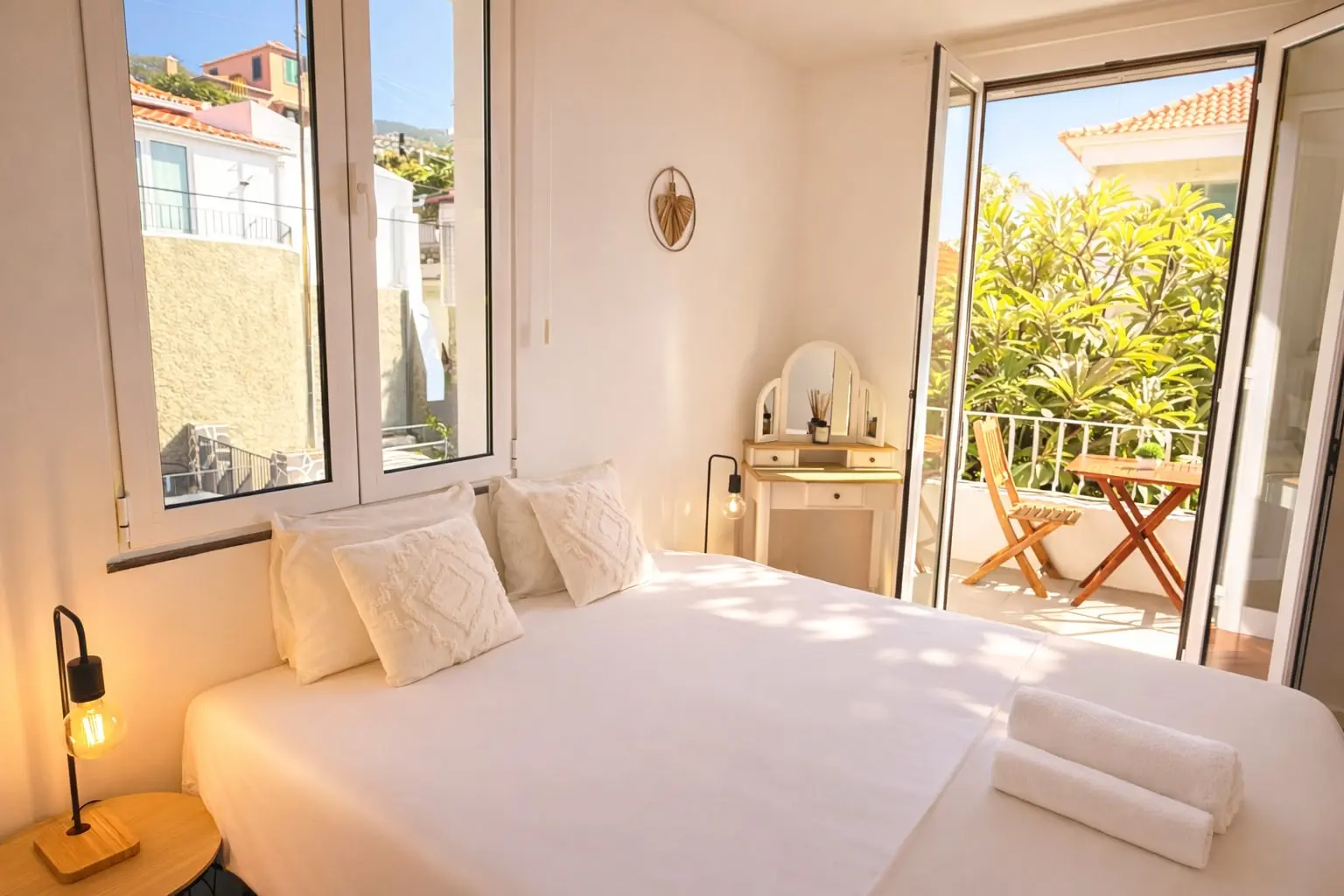 Room 1: bright double bedroom with dressing table and doors to a balcony